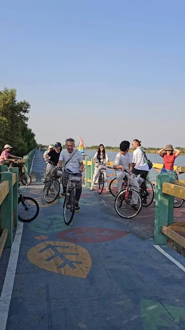 Friends cycling together across a bridge