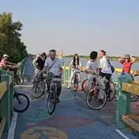 Friends cycling together across a bridge in Singapore